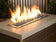 Load image into Gallery viewer, American Fire Products 1/2 inch Pacific Blue reflective fire glass installed in outdoor fire pit creating blue flame reflections