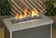 Load image into Gallery viewer, American Fire Products small gray lava stone 1/2 to 1 inch fire pit media use case showing volcanic rock in gas fire pit with flames and decorative fire feature setup