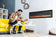 Load image into Gallery viewer, Napoleon Entice 60-inch wall-mounted electric fireplace in a home office with optional decorative logs