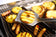 Load image into Gallery viewer, Napoleon GATL007 stainless steel grill spatula lifting a grilled pineapple slice over a barbecue grill
