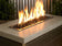 Load image into Gallery viewer, Outdoor fire pit filled with Onyx Medium fire pit glass creating an elegant black glass surface with glowing flames