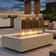 Load image into Gallery viewer, Planika Cabo Fire Table Nacre installed on a modern outdoor patio with decorative flames