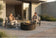 Load image into Gallery viewer, Planika Comet Fire Table Laurent installed on a luxury outdoor terrace with decorative flames