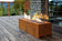 Load image into Gallery viewer, Planika Galio Corten freestanding outdoor gas fireplace installed on a modern patio