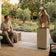 Load image into Gallery viewer, Planika Porto Nacre freestanding fireplace used in a modern outdoor lounge area