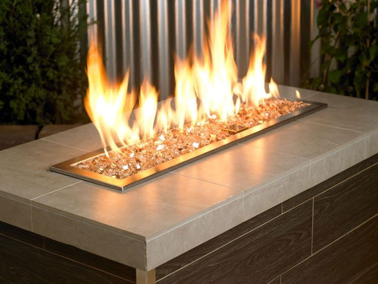 American Fire Products 1/4 inch Champagne reflective fire glass used in an outdoor fire pit creating a warm golden flame display