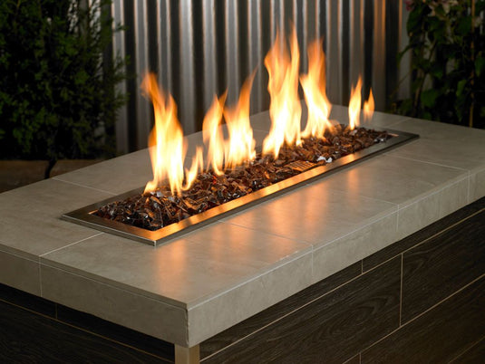 American Fire Products Auburn Recycled Medium Fire Glass displayed in an outdoor fire pit with flames reflecting through the auburn glass