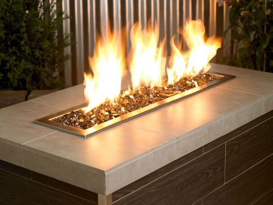 American Fire Products Bronze reflective fire glass used in outdoor fire pit creating warm flame reflection effect