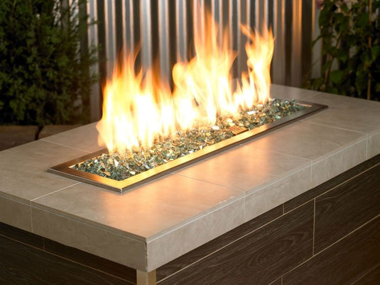 American Fire Products Evergreen reflective fire glass used in outdoor fire pit creating a bold green flame reflection effect