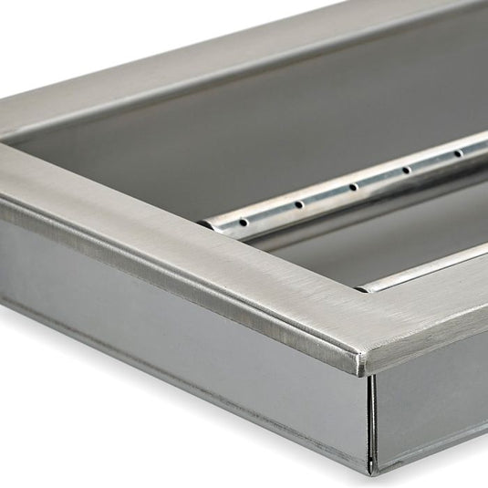 Close-up detail of stainless steel construction of linear burner pan showing brushed metal surface and burner slot design for fire pit use