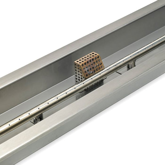 Close-up detail of stainless steel construction of linear burner pan showing brushed metal surface and burner slot design for fire pit use