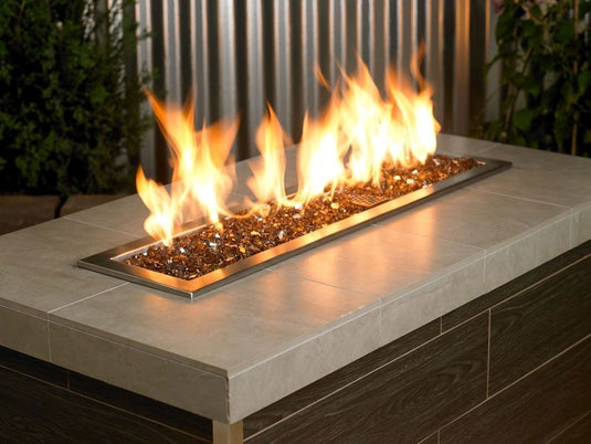 American Fire Products 1/4 inch Copper reflective fire glass used in outdoor fire pit creating a warm golden flame display
