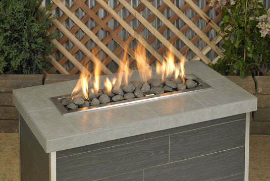Fireplace linear lite stones in thunder grey color with visible flame, modern ceramic fire media arranged in a linear gas fireplace design for indoor and outdoor fire features.