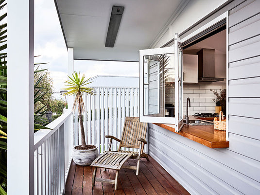 HEATSTRIP Classic with Remote and App heater installed above a covered balcony seating area