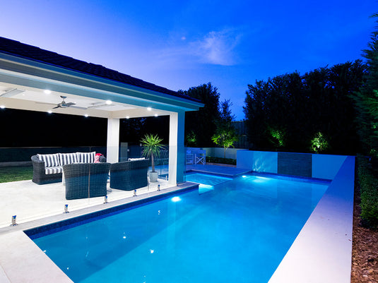 White HEATSTRIP heaters installed above a covered poolside seating area