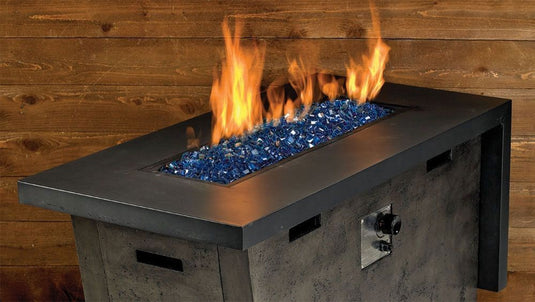 Luxury outdoor fire pit featuring Pacific Blue Luster 2.0 Fire Glass Cubes with blue glass reflecting warm flames