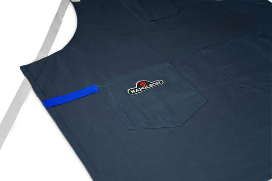 Close-up of the navy Napoleon apron with embroidered logo, front pockets and blue accent