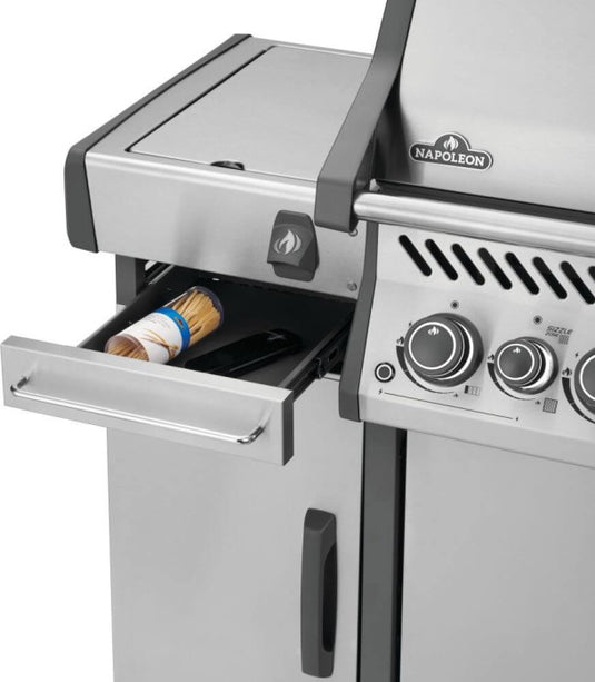 Napoleon 68008 stainless steel storage cart installed beside a Rogue PRO grill with upper drawer open for grilling accessories