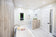 Load image into Gallery viewer, Napoleon Allure Vertical 32-inch electric fireplace mounted on a bathroom wall with green accent lighting
