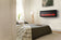 Load image into Gallery viewer, Napoleon Entice 42-inch wall-mounted electric fireplace in a contemporary bedroom with optional decorative logs
