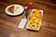 Load image into Gallery viewer, Napoleon griddle spatula displayed beside a breakfast platter with grilled pineapple, eggs, and bacon
