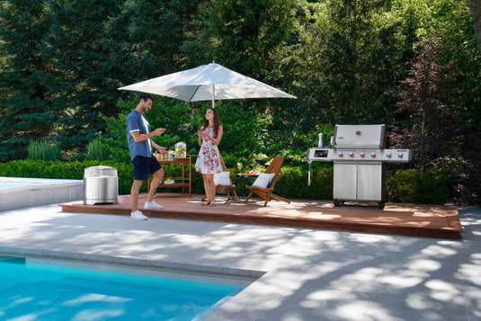 Napoleon Prestige PRO 500 grill on a poolside deck with two people nearby