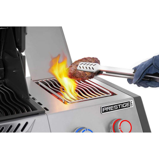 Steak held with tongs above the glowing infrared side burner on a Napoleon Prestige PRO 500