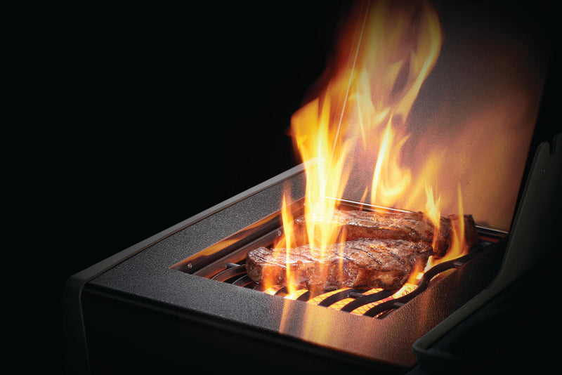 Load image into Gallery viewer, Grilled steak on a portable grill with flames against a dark background
