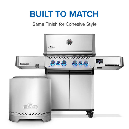 Napoleon Timberwolf 18-inch stainless steel smokeless fire pit (NWFPMTI-SS) displayed beside a Napoleon Prestige gas grill, highlighting their matching stainless steel finishes.