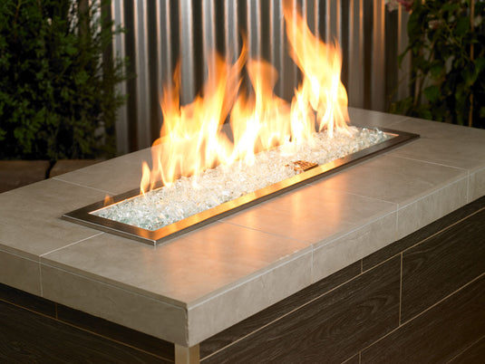 Outdoor fire pit filled with 1/2 inch Clear Fire Glass producing bright flames and modern decorative appeal