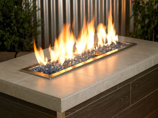 Outdoor fire pit filled with 1/2 inch Pacific Blue Fire Glass producing vibrant flames and modern decorative appeal