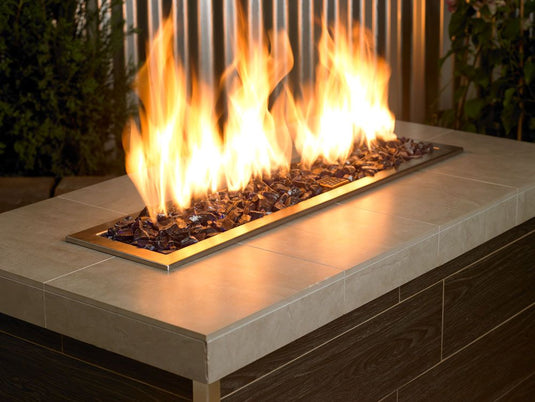 Outdoor fire pit filled with Dark Blue Medium fire pit glass producing vibrant flames and a modern decorative appearance