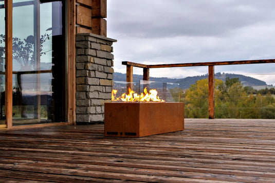 Planika Galio Corten freestanding outdoor gas fireplace installed on a modern patio