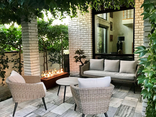 Planika Galio Corten freestanding outdoor gas fireplace installed on a modern patio