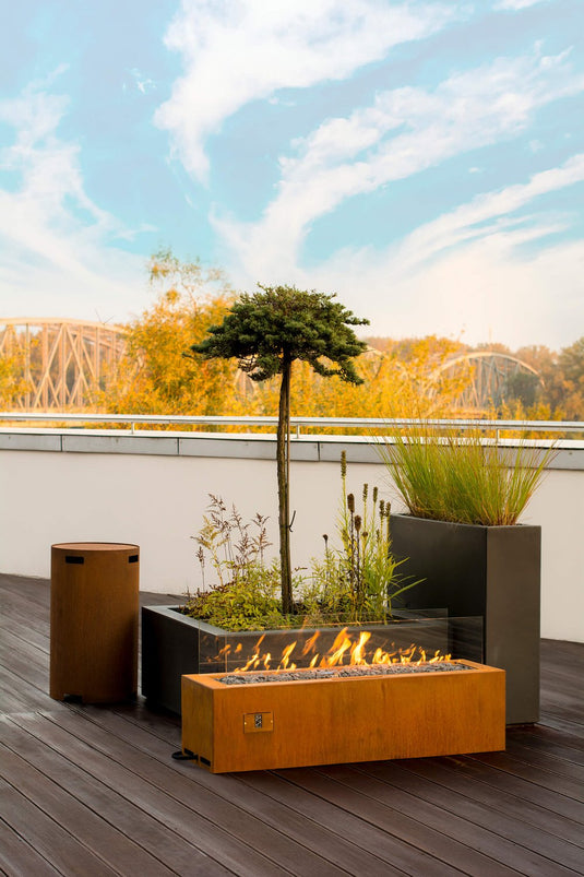 Planika Galio Corten freestanding outdoor gas fireplace installed on a modern patio