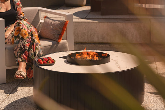 Planika Stella Daze outdoor gas fire table installed on modern luxury patio with decorative flames