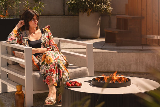 Planika Stella Daze outdoor gas fire table installed on modern luxury patio with decorative flames